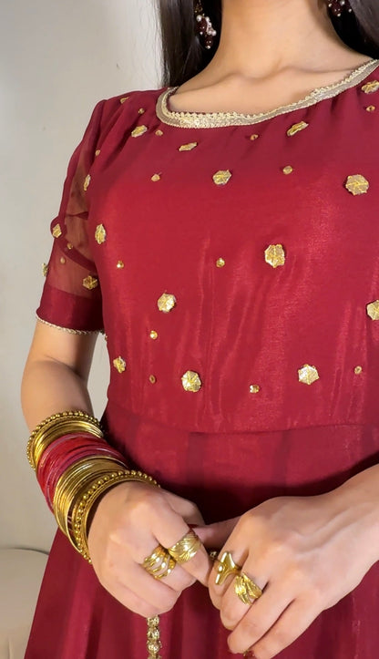 Close crop of Aatish maroon chiffon frock highlighting the rounded neckline, gold motifs and short sleeves