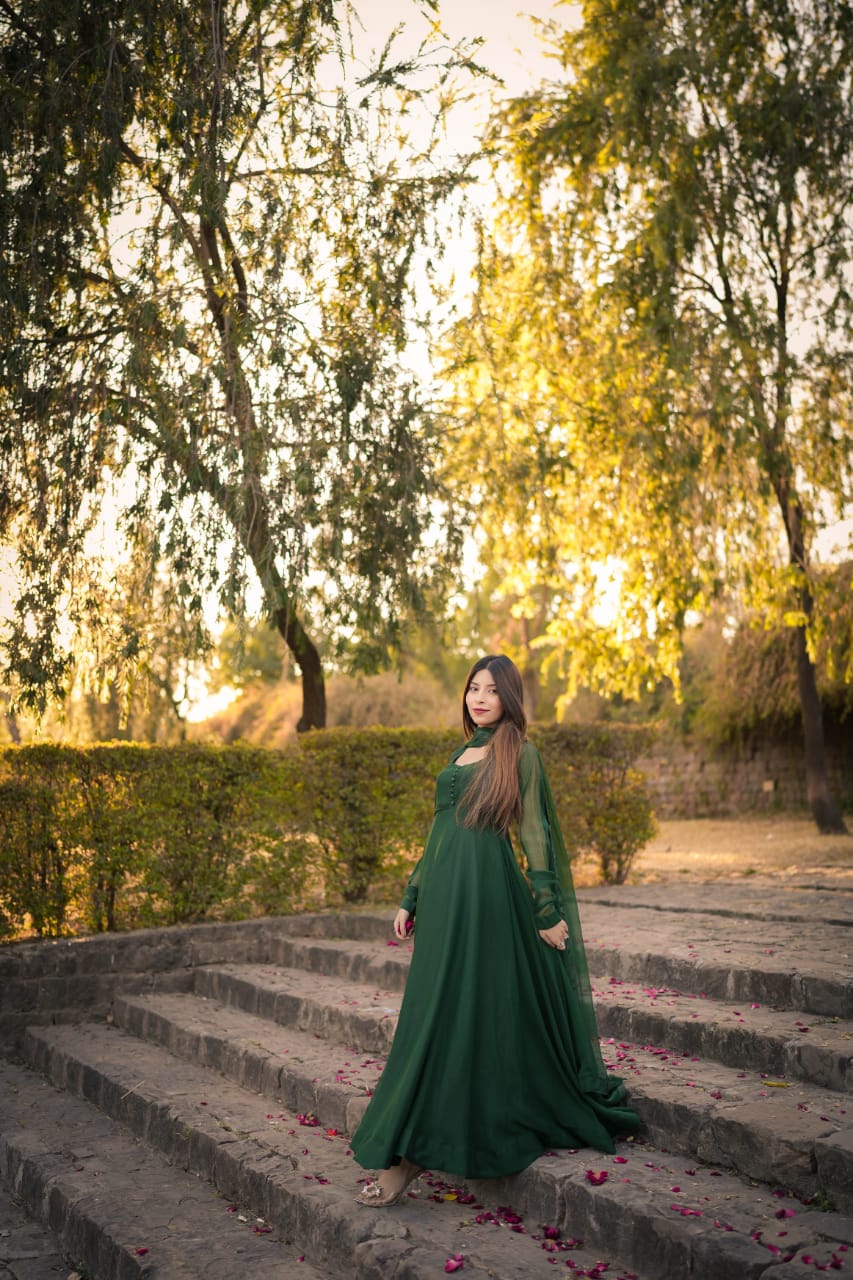 Abroo emerald chiffon frock in a staircase standing pose with full flare, long sleeves and matching dupatta
