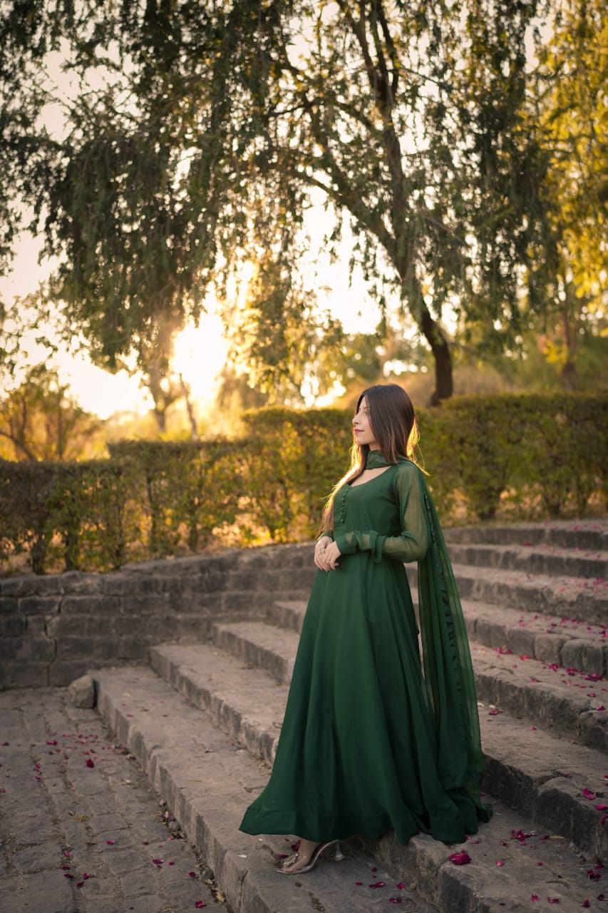 Side outdoor view of Abroo green chiffon frock with flowing flare, long sleeves and coordinated chiffon dupatta