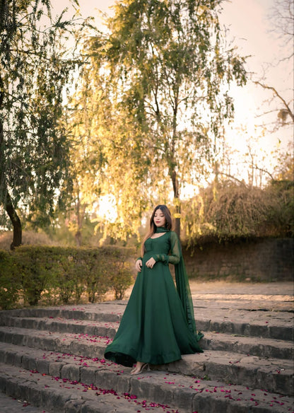 Wide outdoor view of Abroo green chiffon frock on stone steps with full flowing silhouette, long sleeves and matching dupatta
