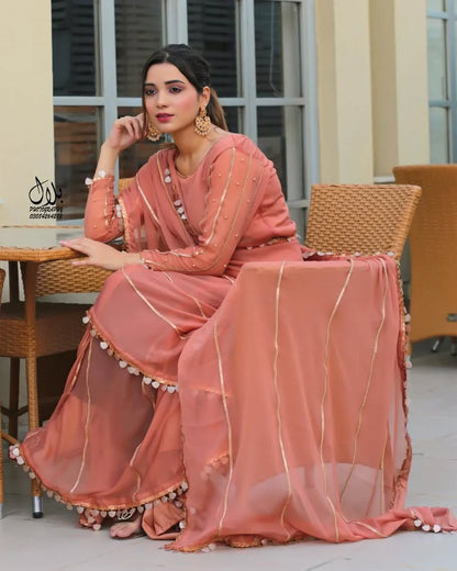 Aster Dusty Rose chiffon saree in seated side pose highlighting lace-trimmed pallu and flowing drape by Anabiyawear
