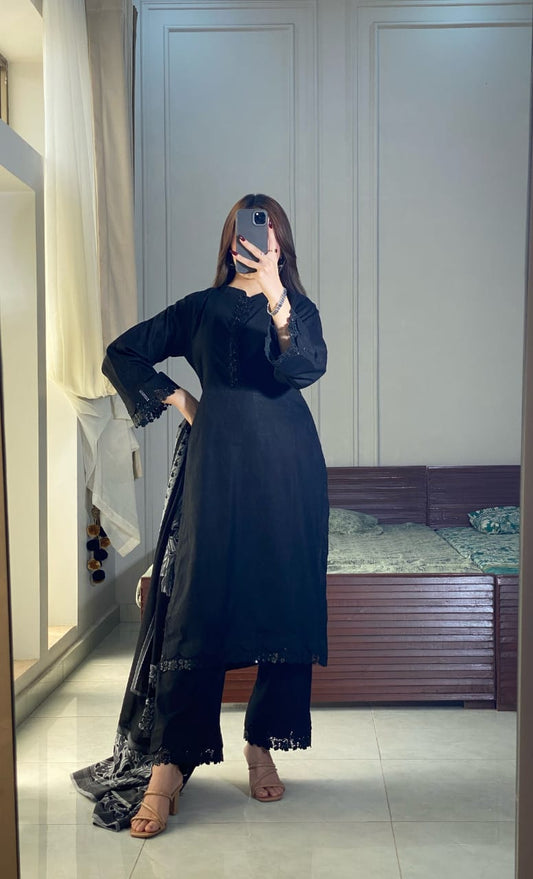 Black Aura lawn three piece outfit in a hand-on-waist pose with black straight shirt, matching trousers and patterned jacquard dupatta