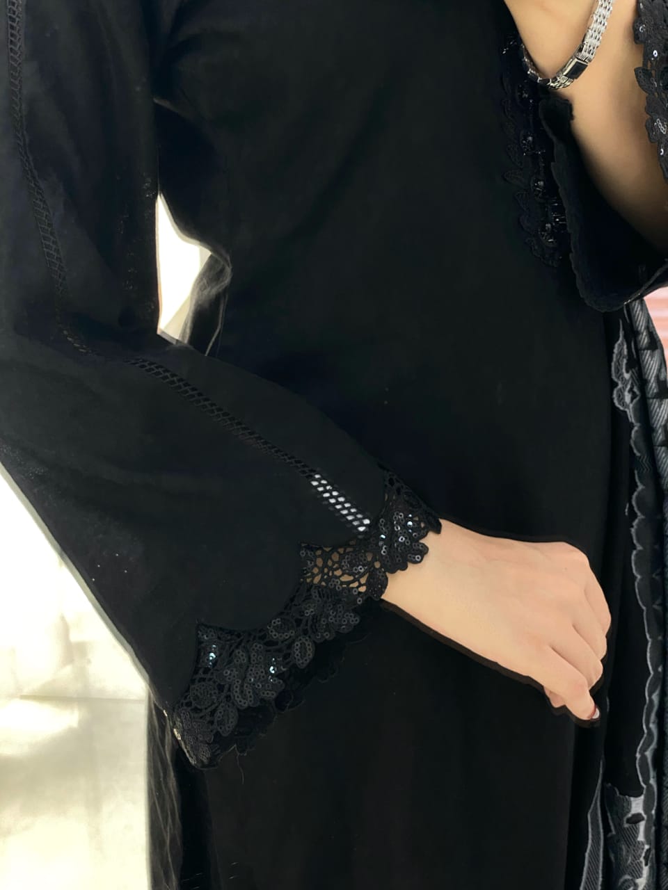 Close-up of Black Aura black lawn shirt showing decorative lace detailing on the sleeve cuff and refined finishing