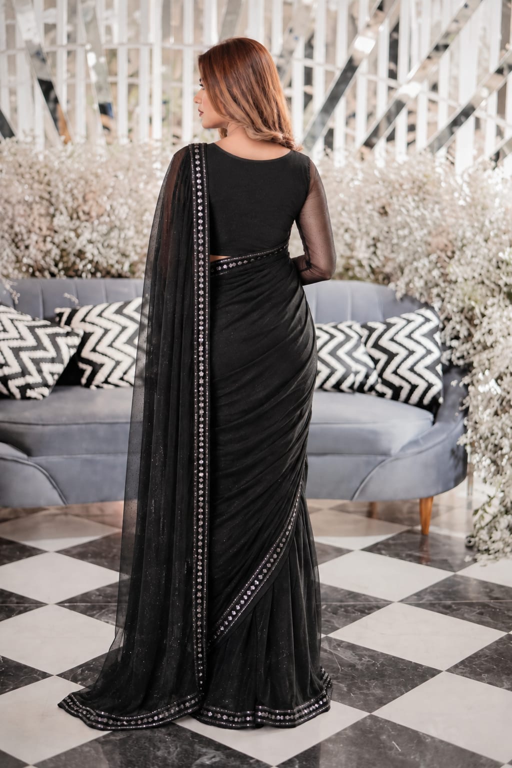 Black Berry chiffon saree shown from the back with a long flowing pallu and contrast lace border