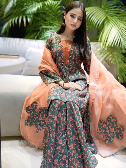 Breeze Charm printed lawn palazzo suit in seated pose with peach organza applique dupatta by Anabiyawear
