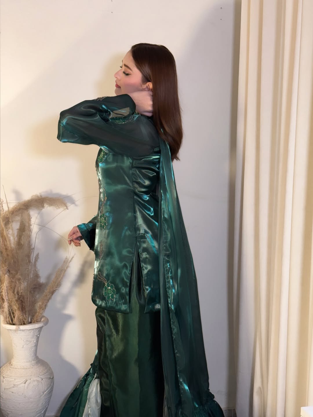 Rear angle of a model presenting Anabiyawear’s deep green formal ensemble with a lustrous finish