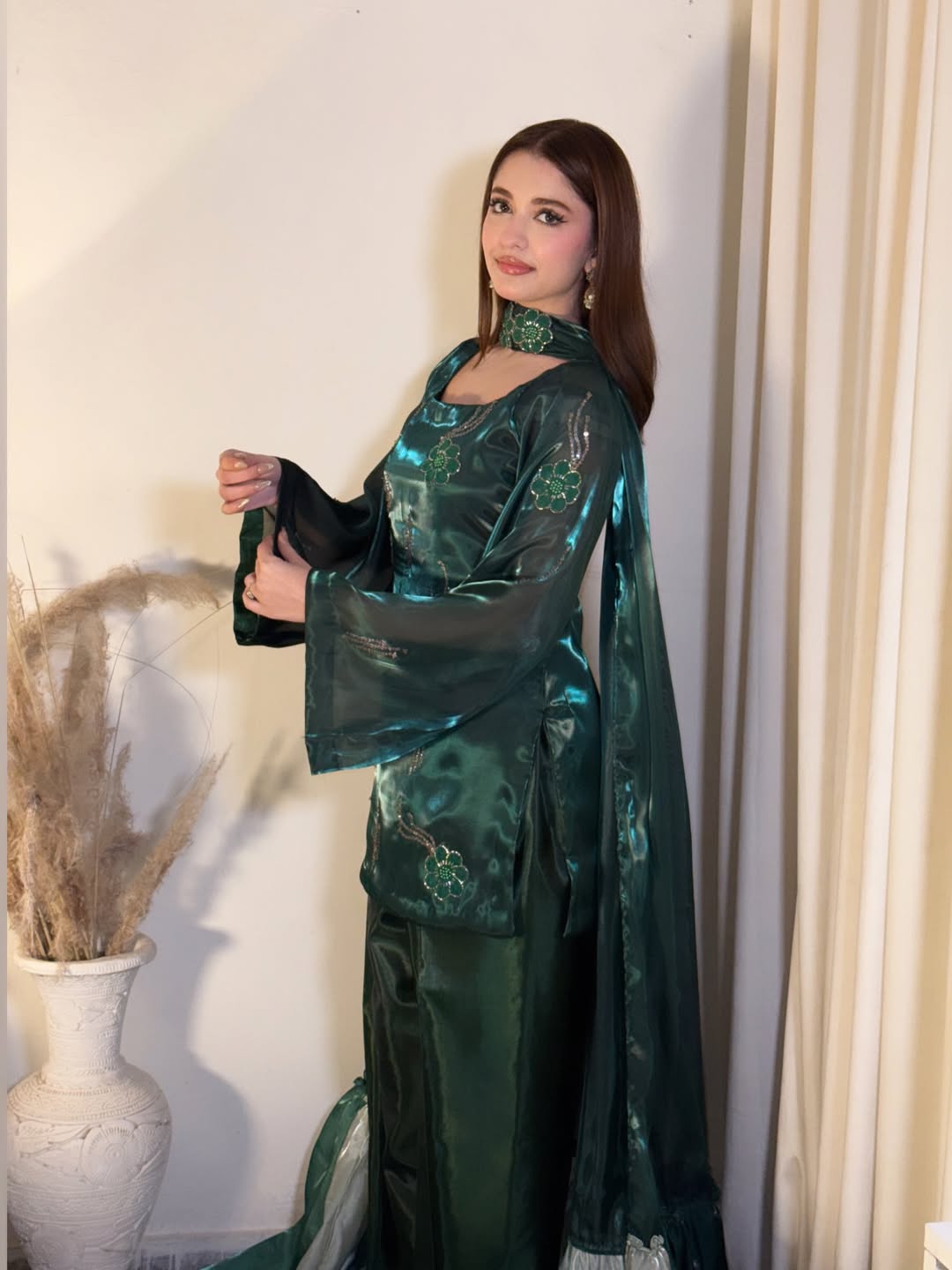 Model showcasing an emerald green traditional women’s outfit by Anabiyawear in an indoor setting