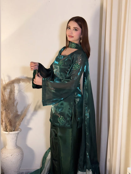 Model showcasing an emerald green traditional women’s outfit by Anabiyawear in an indoor setting