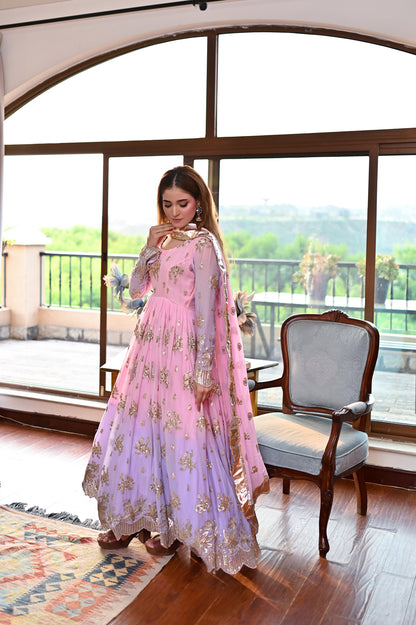 Lavender Blush formal chiffon maxi in a window-side pose with pastel lavender tones, floral embellishment and soft flowing silhouette