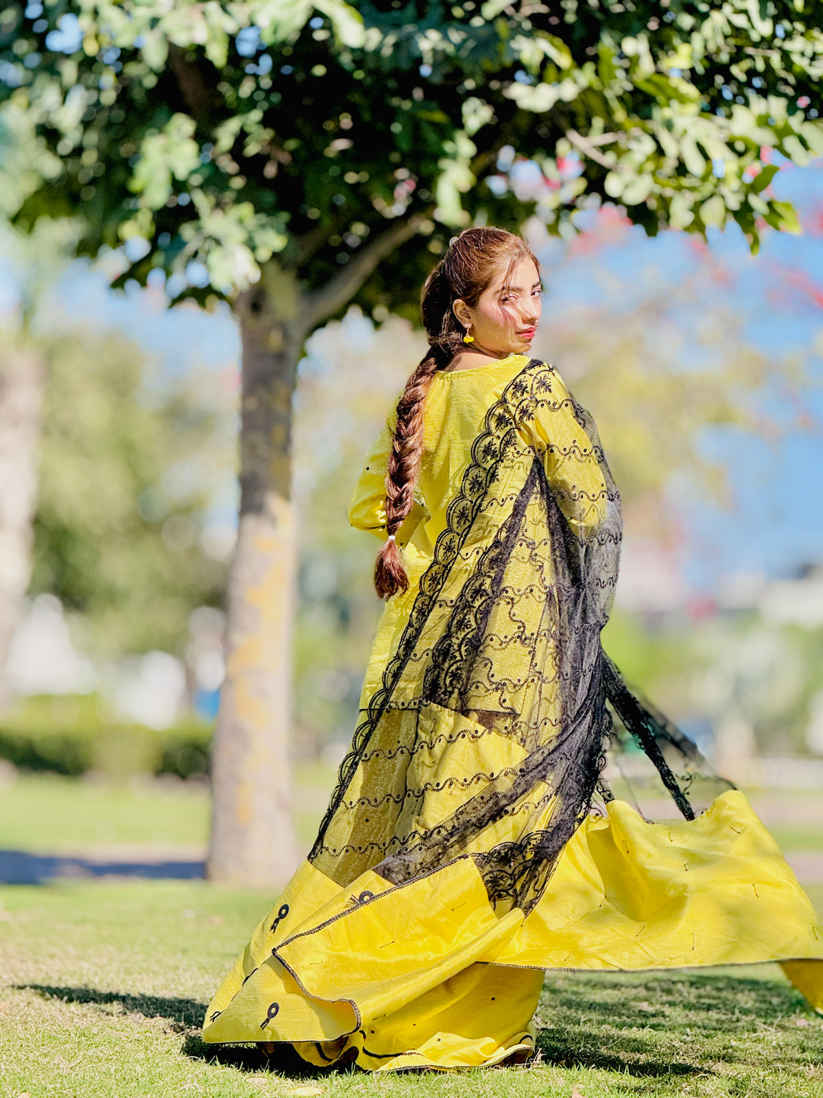Back view of Primrose yellow kalidar lehenga with black embroidered dupatta by Anabiyawear