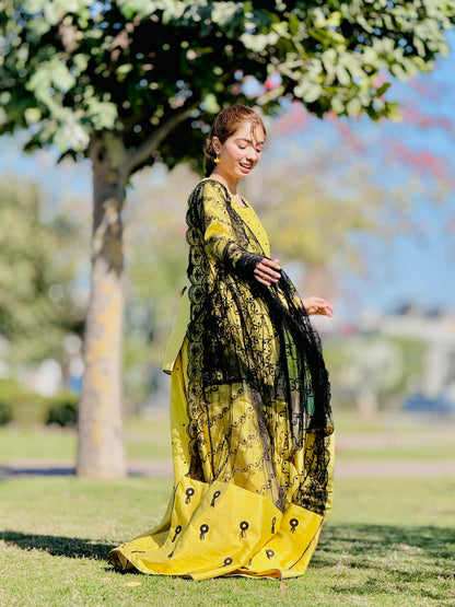 Primrose yellow kalidar lehenga with black embroidered dupatta in side view by Anabiyawear