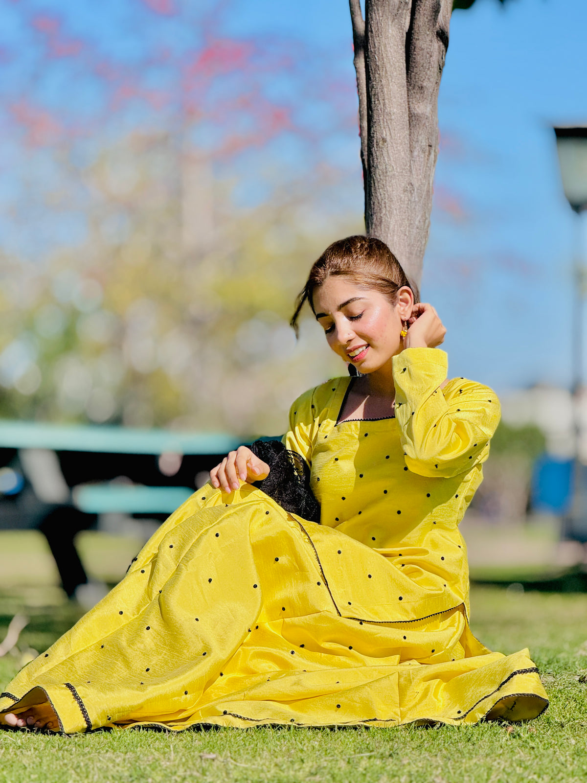 Primrose yellow raw silk kalidar lehenga set in relaxed seated pose by Anabiyawear