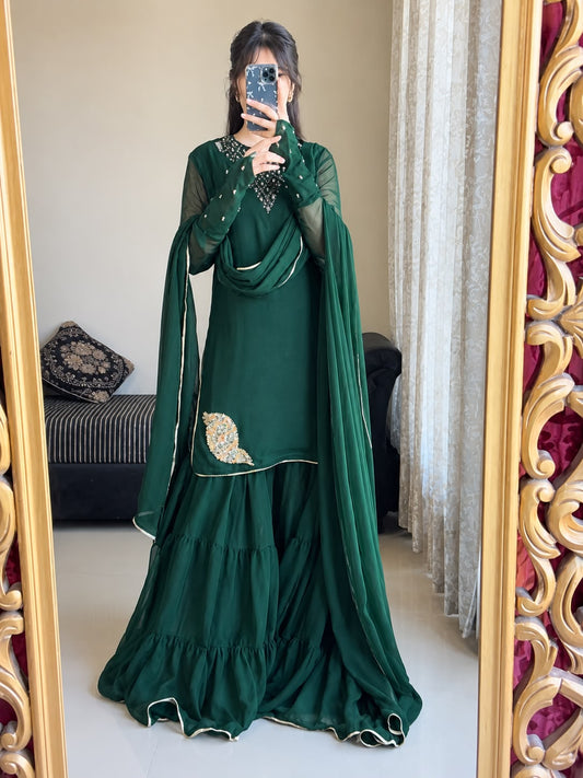 Rang-e-Shabnam bottle green chiffon gharara outfit in a mirror pose with layered bottom, ring sleeves and draped lace dupatta