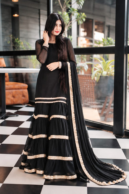 Rebel black chiffon garara suit with layered golden lace detailing and matching dupatta by Anabiyawear