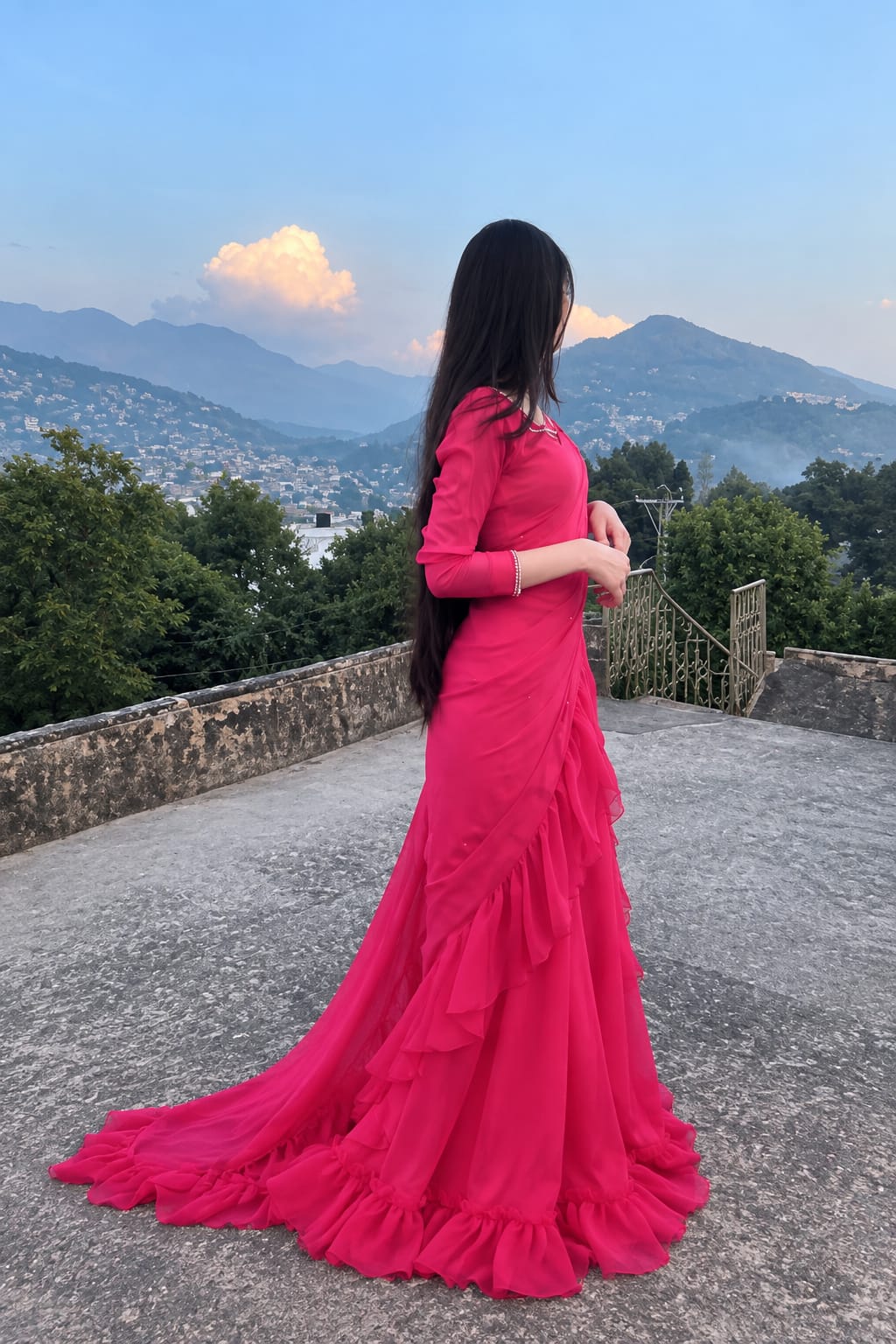 Side view of Ruffle Bloom fuchsia chiffon saree with cascading ruffle drape, flowing hem and elegant outdoor terrace styling