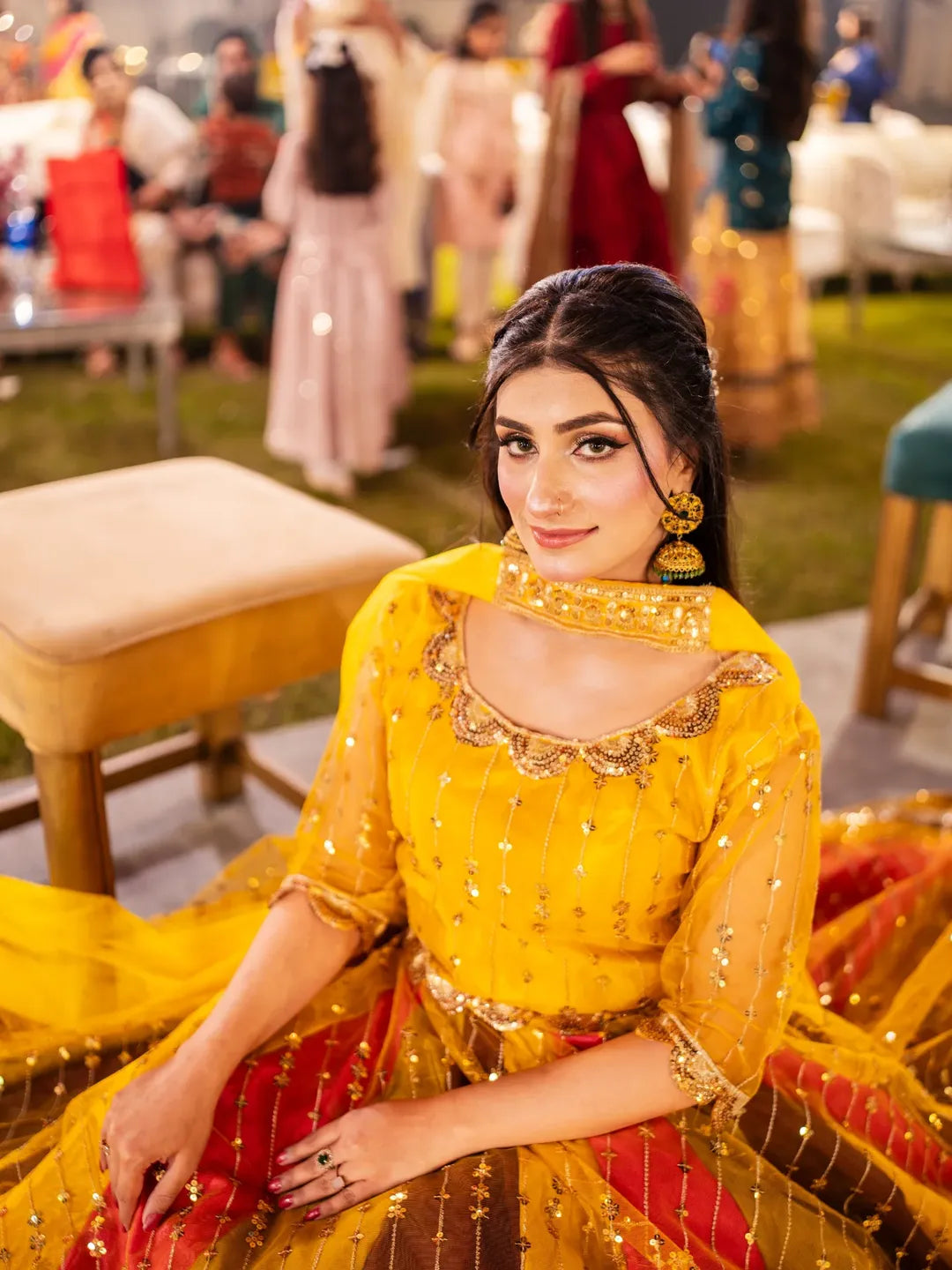 Seated view of Signature Mehndi Lehenga Kurti with yellow embroidered kurti and multicolor festive lehenga