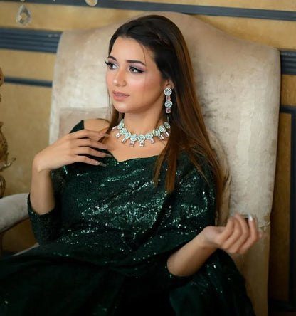 Snowdrop Bottle Green sequin net saree in portrait pose with draped pallu and embellished blouse by Anabiyawear