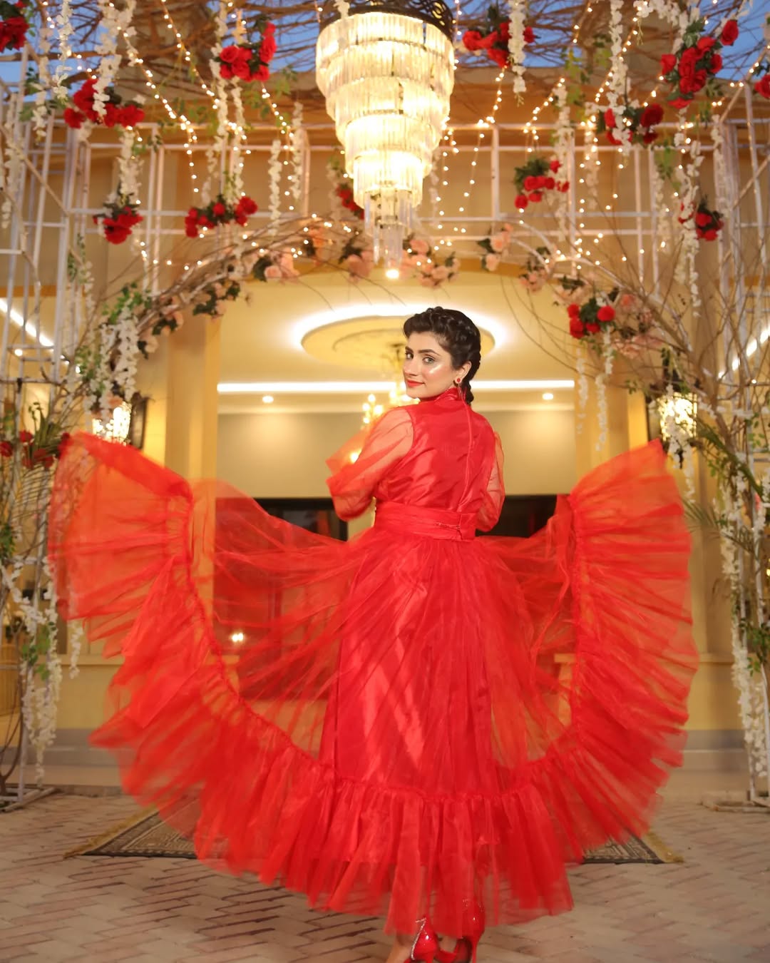 Back pose of Valentine red maxi highlighting the wide layered flare and flowing net design