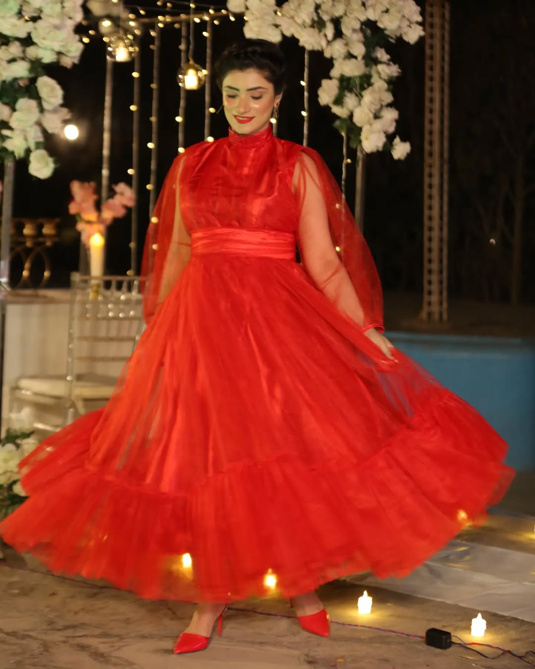 Full-length front view of Valentine red maxi with a flowing skirt, sheer sleeves and fitted waist