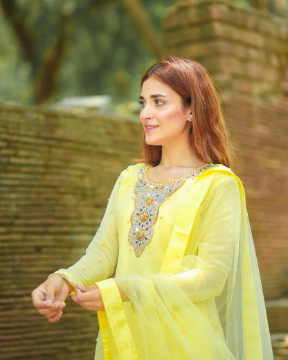 Zari Lemon chiffon sharara outfit in side portrait with mirror embellished neckline and flowing dupatta by Anabiyawear